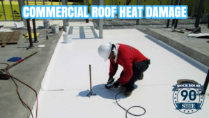 Technician inspecting commercial roof heat damage on an industrial building